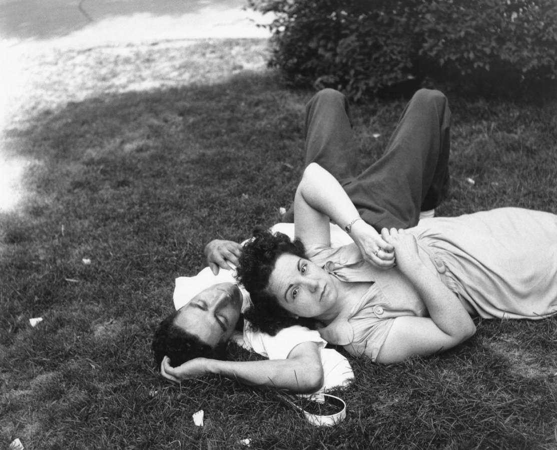 black-and-white photograph of a man and woman laying in the grass