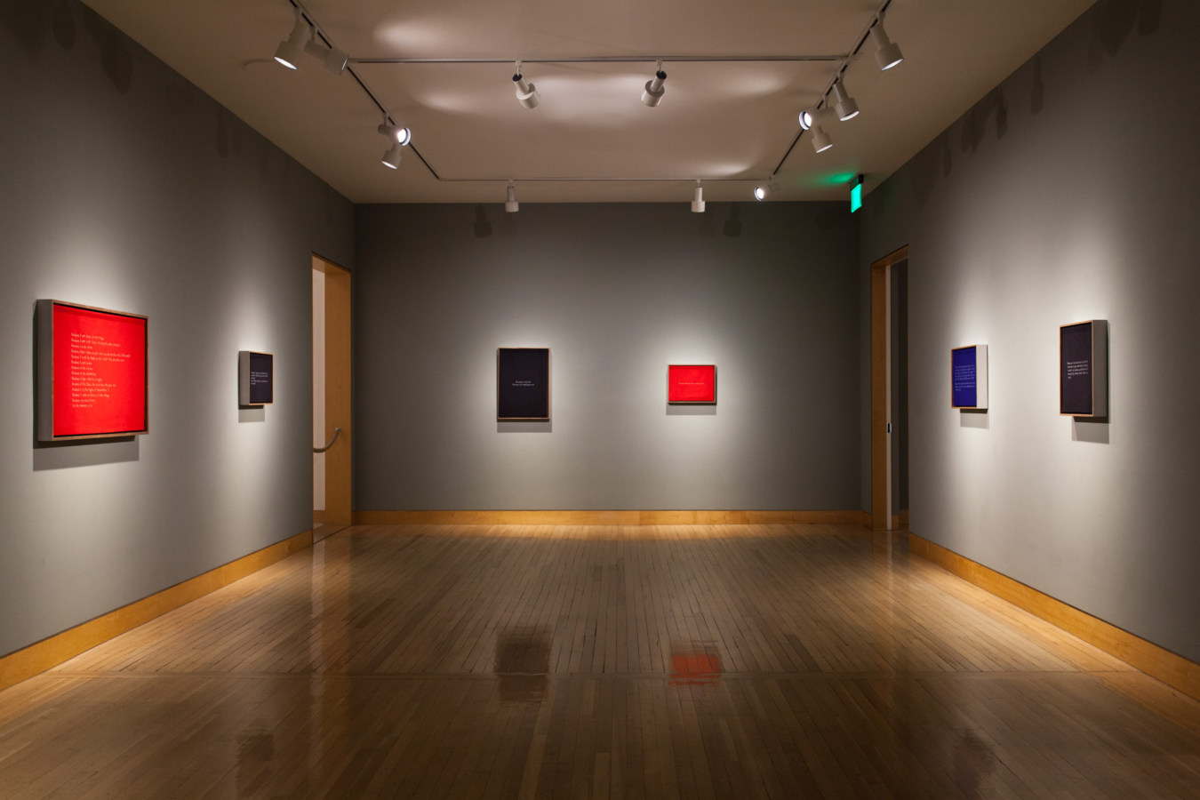 Color image of mixed media works on grey gallery walls