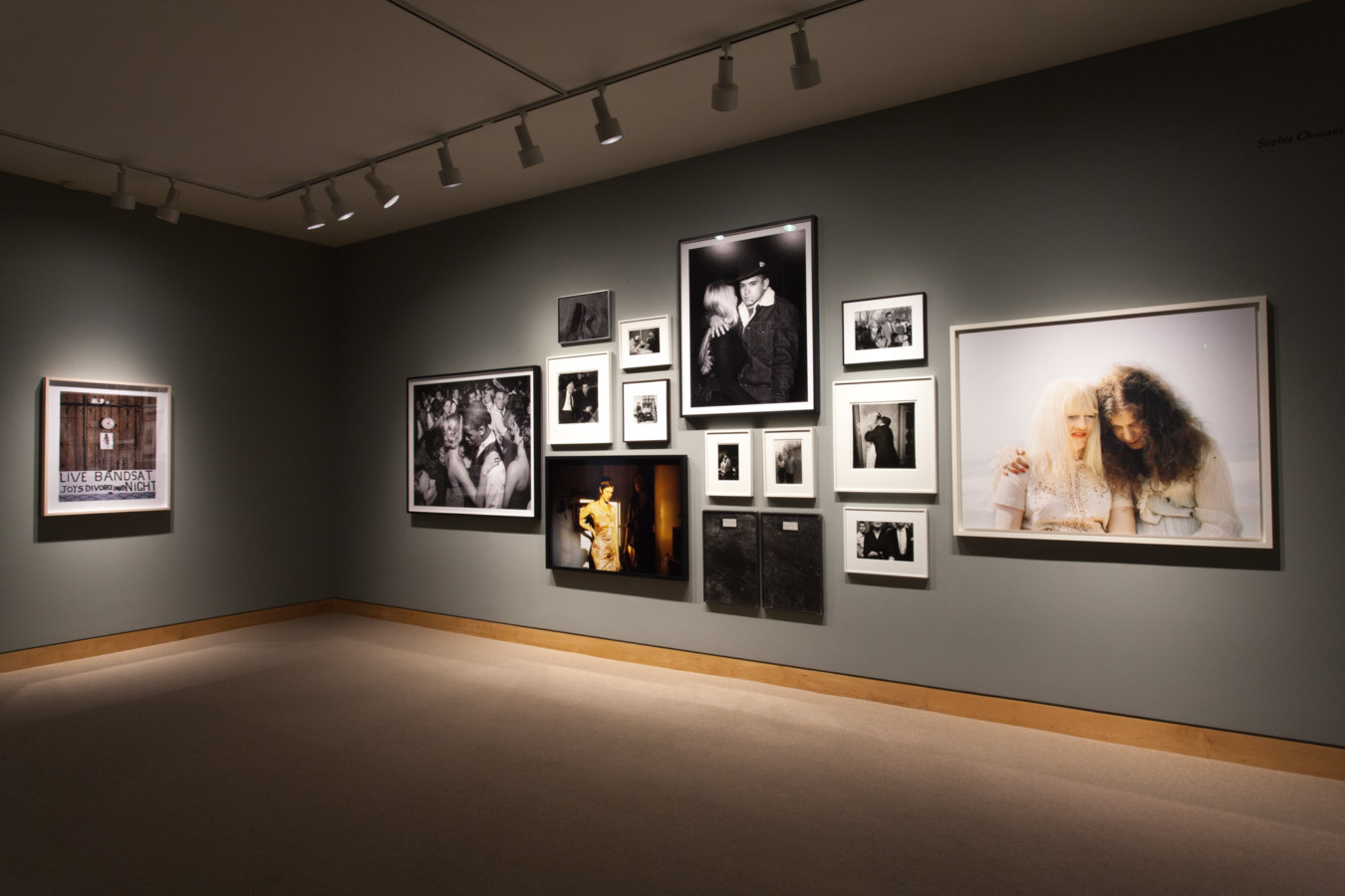 Color image of framed photographs on grey gallery walls