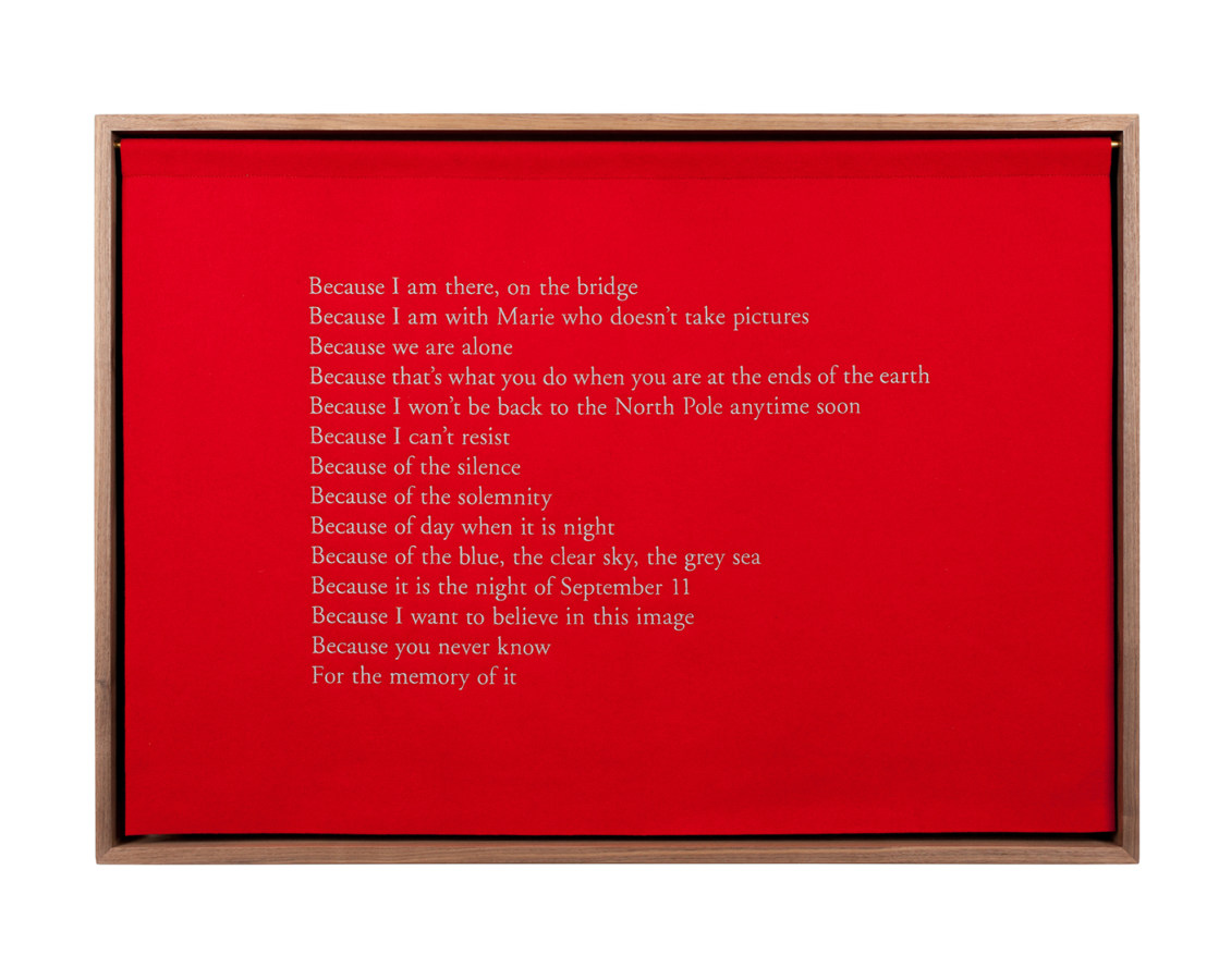 A wooden box with a red felt curtain with white embroidered text, describing the experience of being at the North Pole