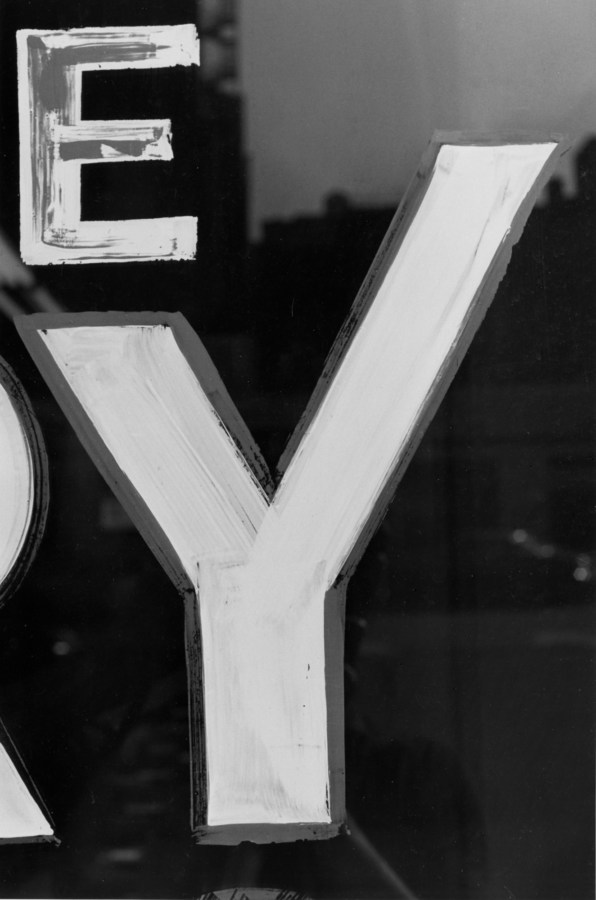 Black and white photograph of a detail of a hand painted sign
