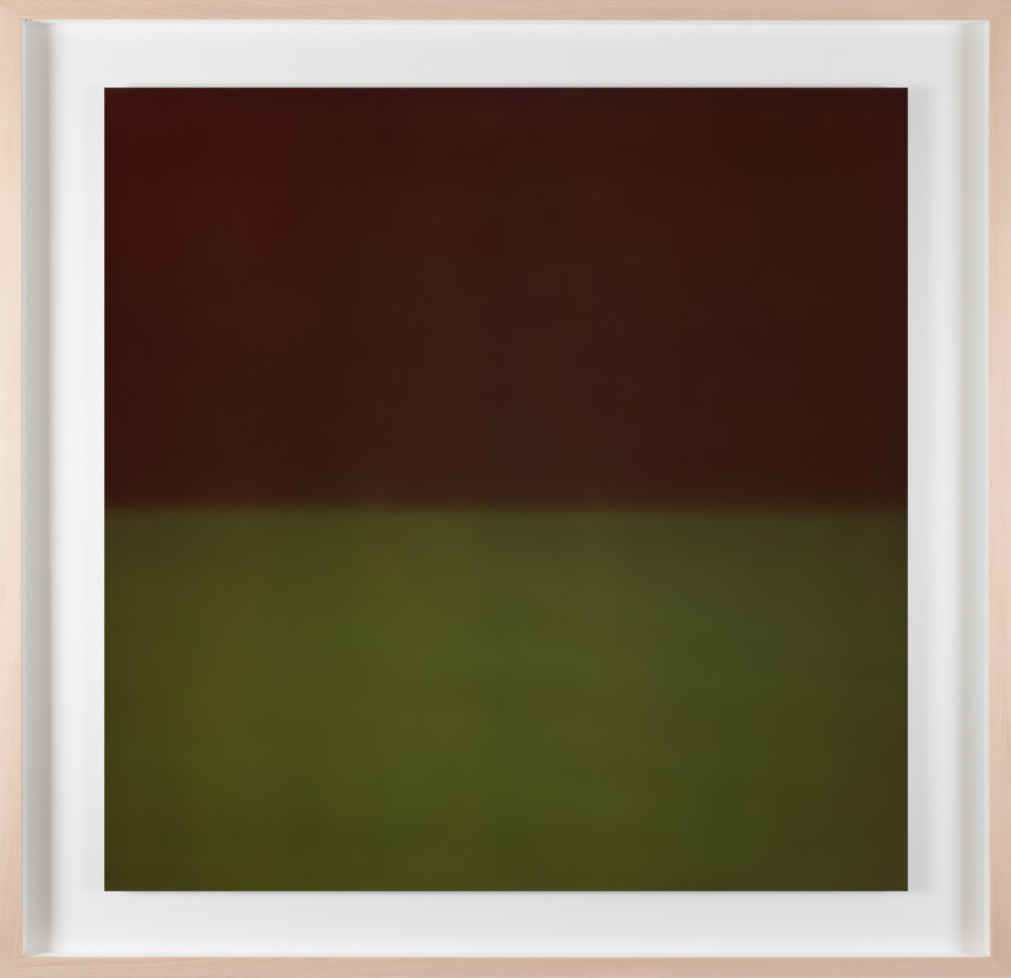 A framed photograph of a color field, top half is black, bottom half is forrest green