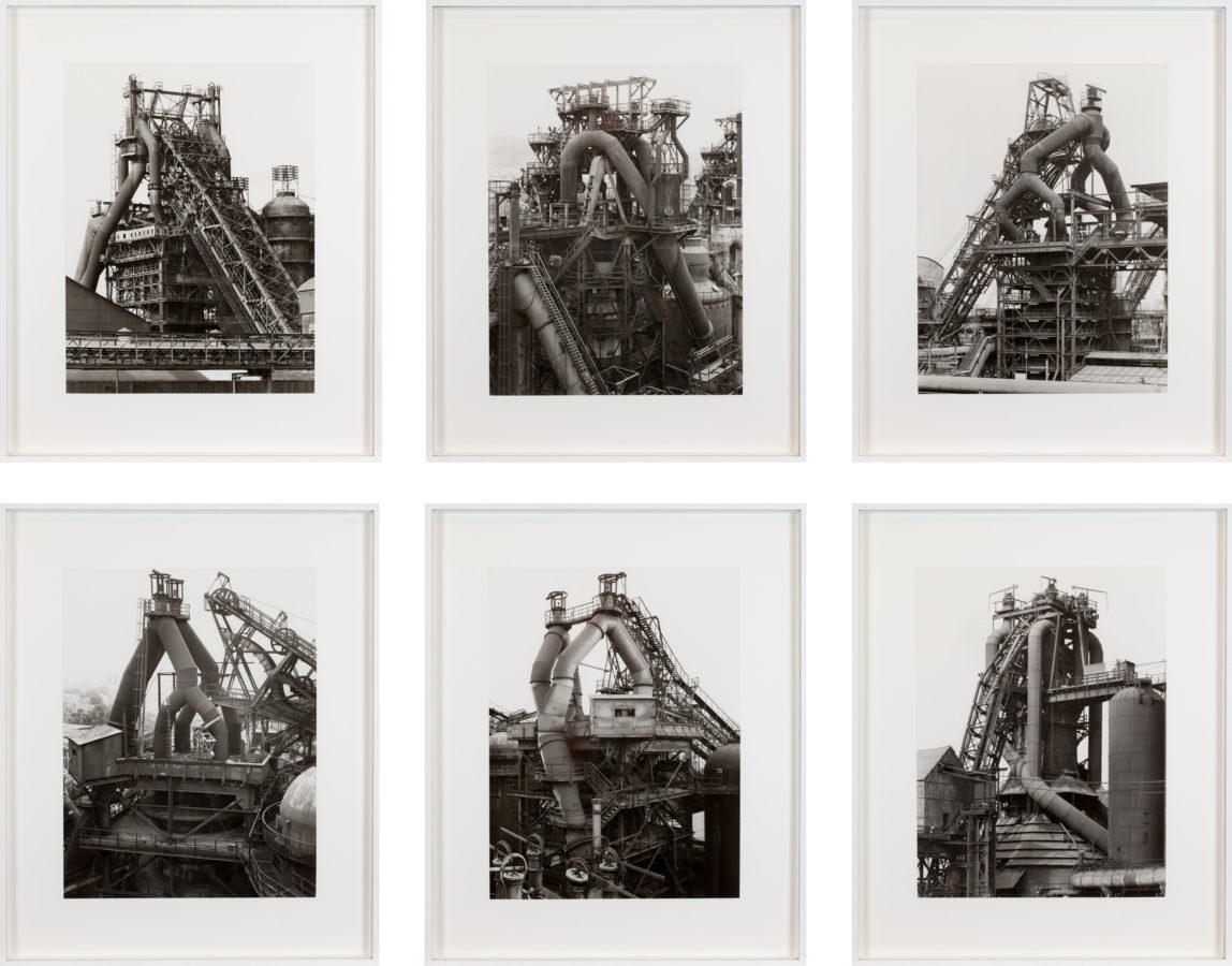 Grid of six framed black and white photographs of blast furnaces
