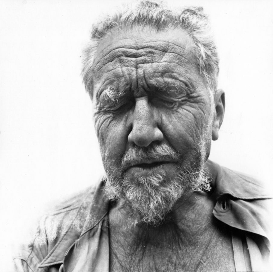 Black and white photograph of a head and shoulders portrait of a man with his eyes closed.