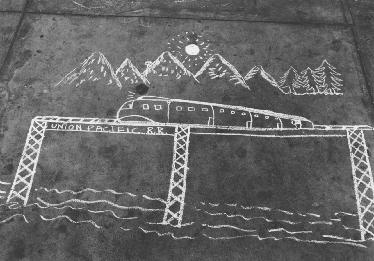 Black-and-white photograph depicting a sidewalk chalk drawing of a train on an elevated bridge, mountains, trees, and sun.