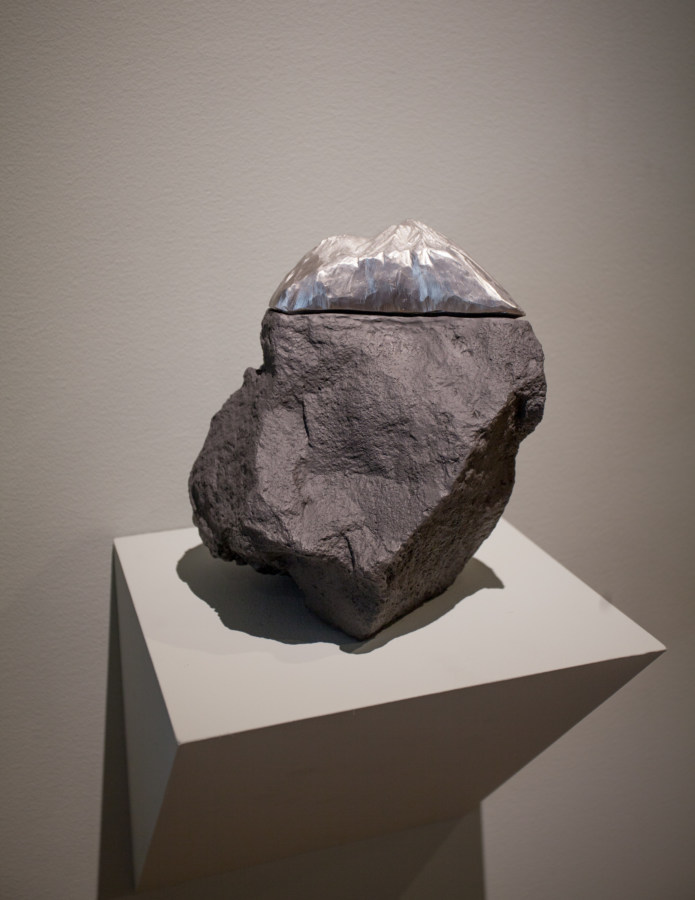 Stone seated on a shelf capped with a silver slice on top