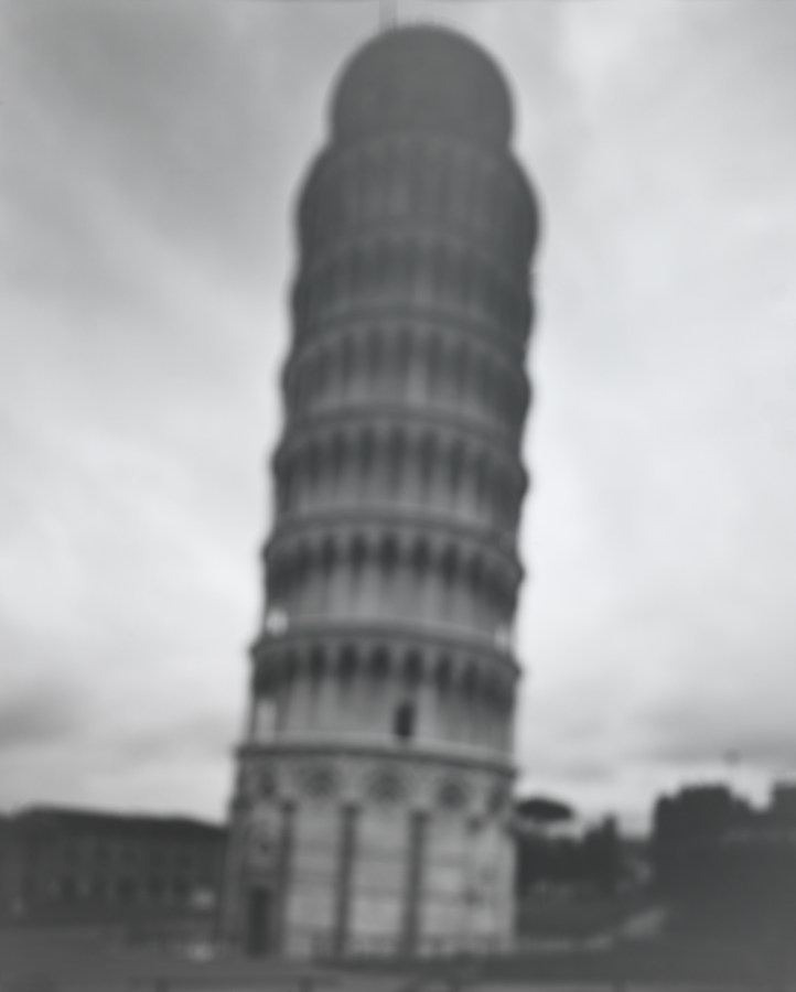 A black and white photograph, slightly blurred, of the Leaning Tower of Pisa