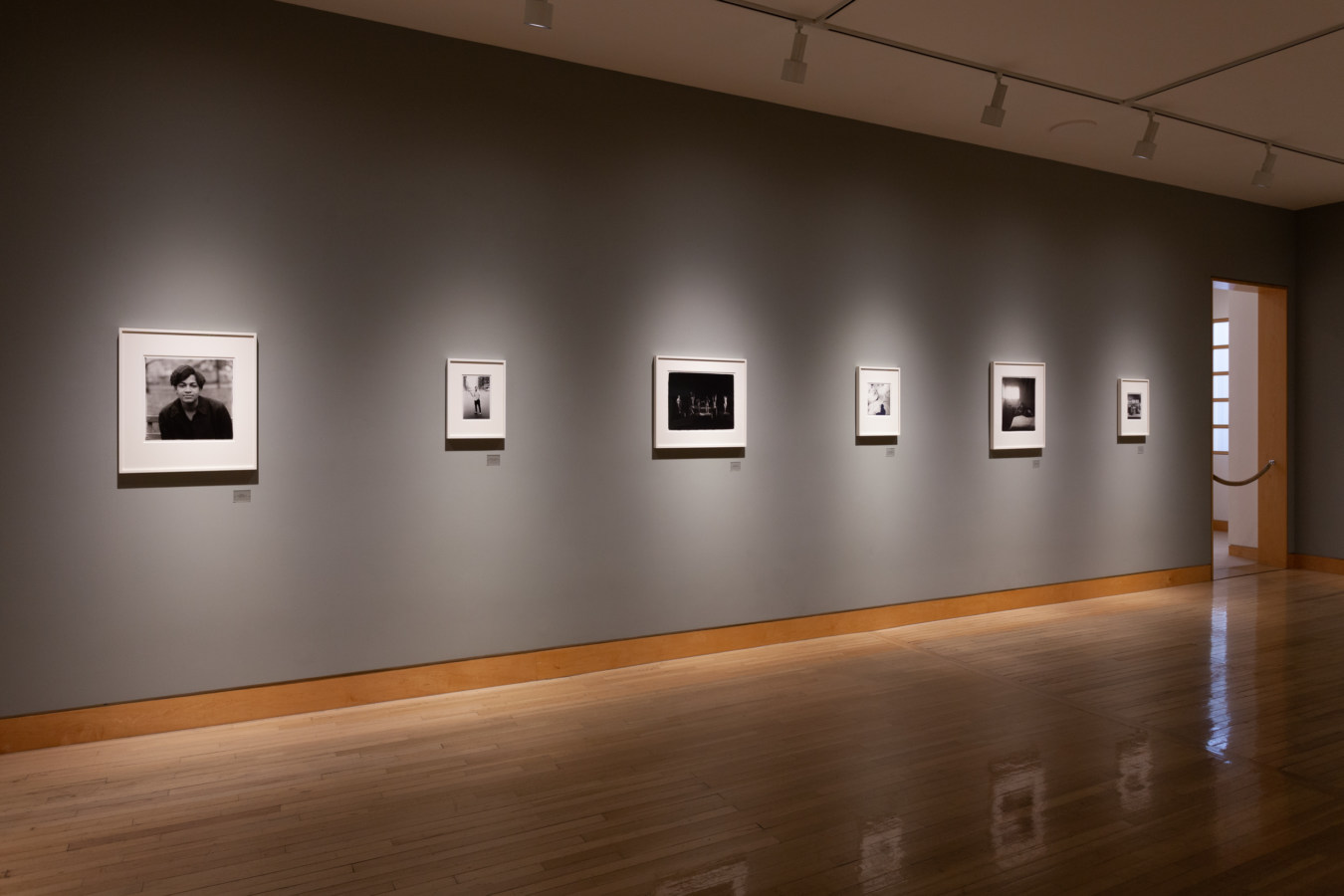 Color image of framed black and white photographs on grey gallery wall