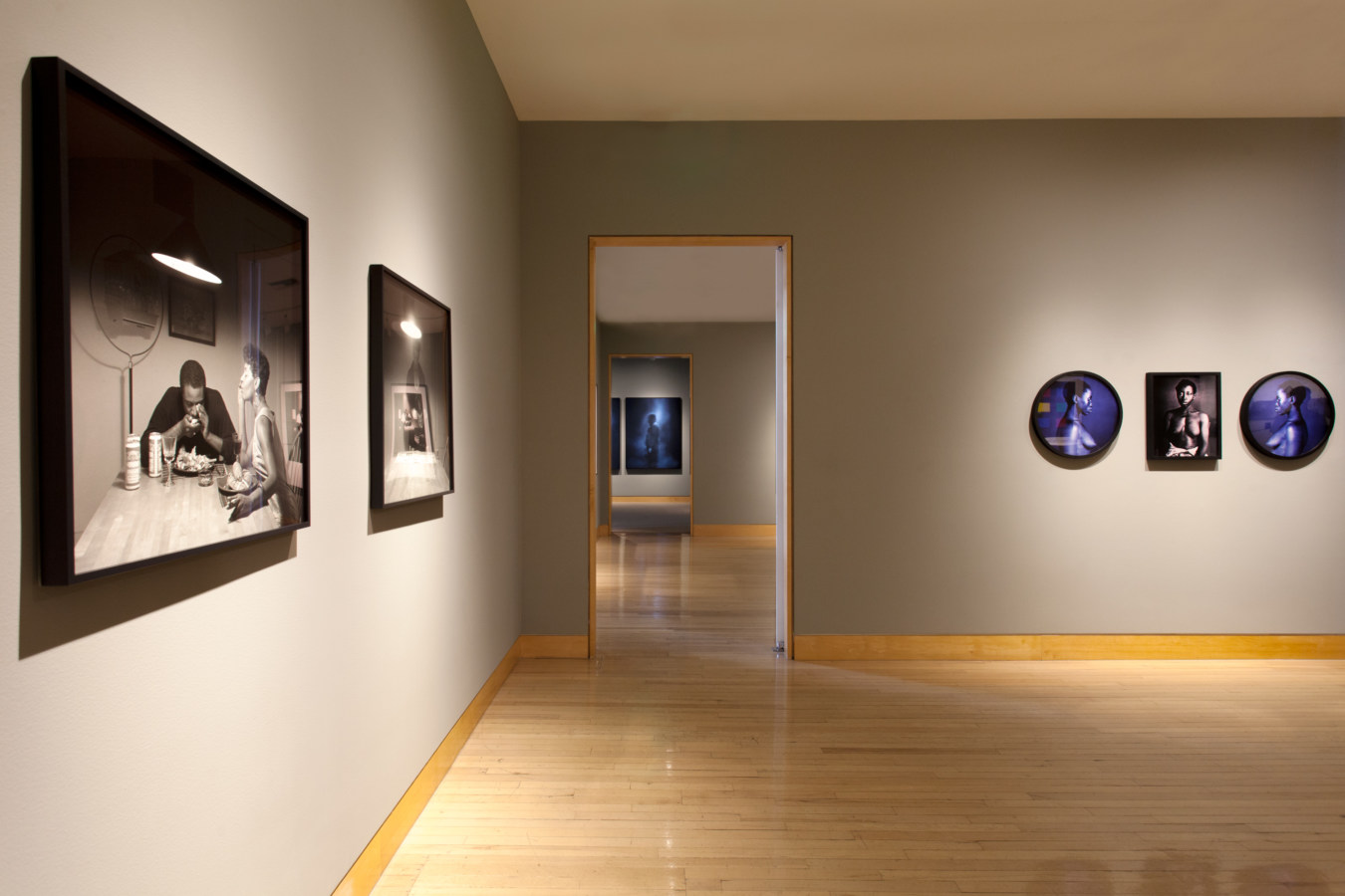 Color image of framed prints on grey gallery walls