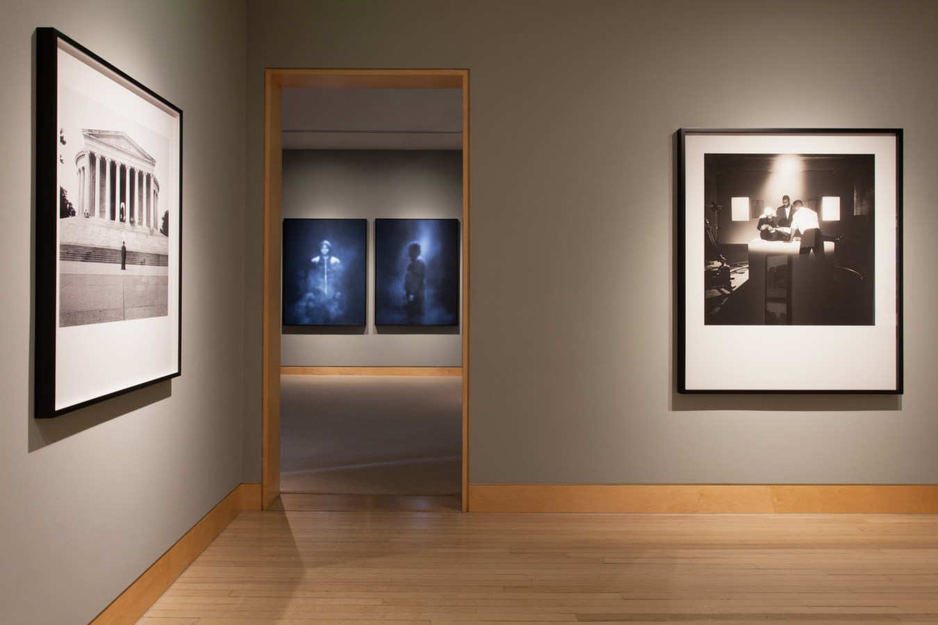 Color image of framed prints on grey gallery walls