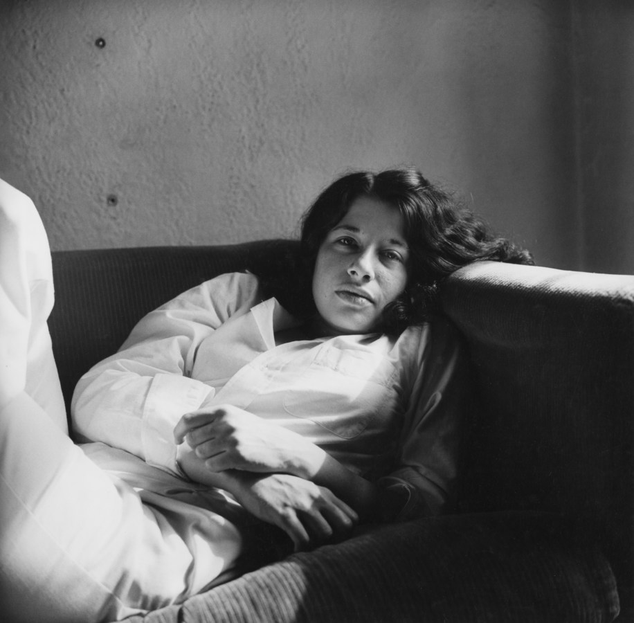 Black-and-white photograph of Fran Lebowitz reclining on a couch.