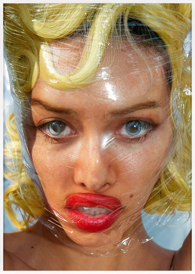 Color photograph of a blonde woman with clear plastic wrapped tightly around her head