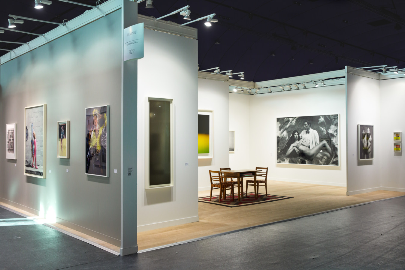Color image of various artworks installed in an art fair booth on white walls