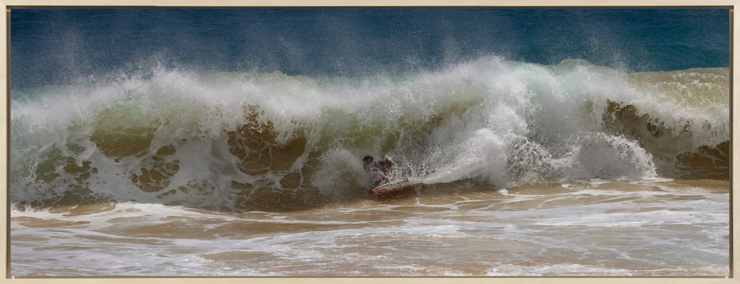 Framed color photograph of a surfer falling in the breaking wave.