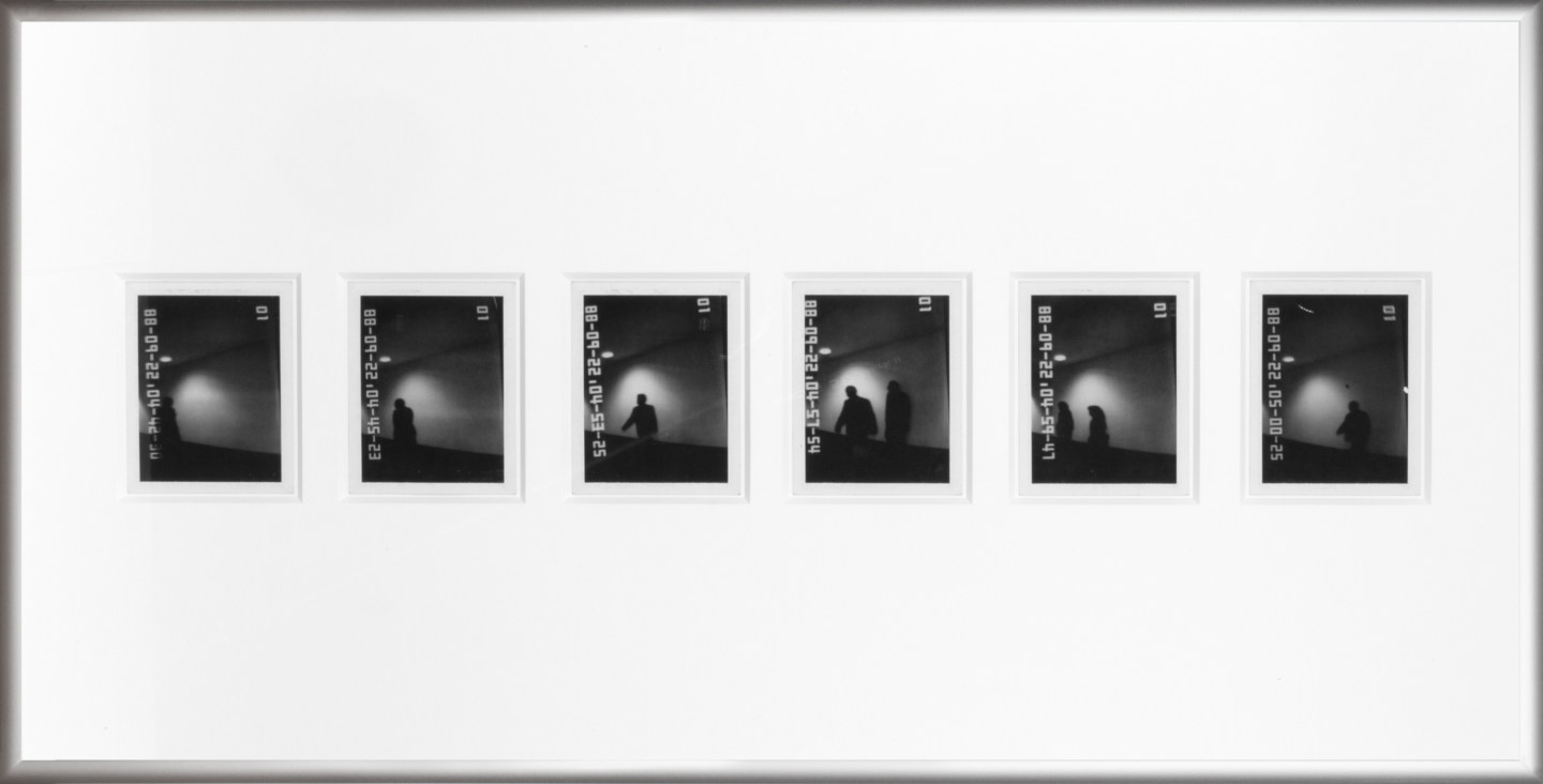 Color image of six black and white polaroids with time stamps depicting shadowy figures in silver frame