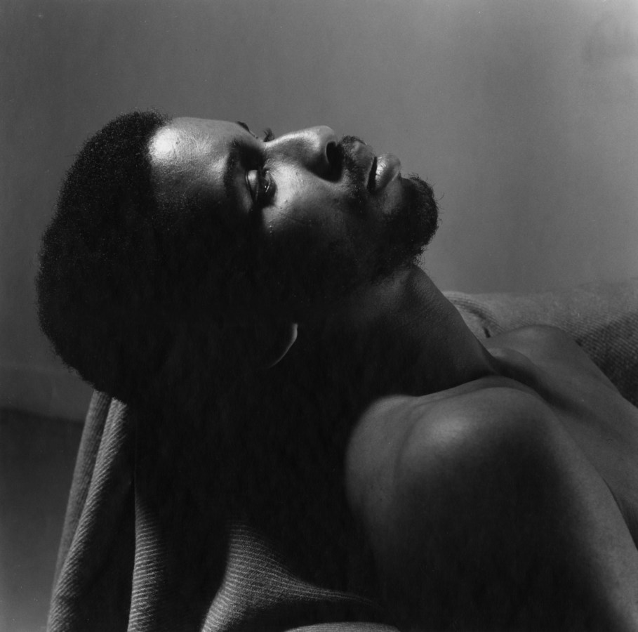 Black and white photograph of a man reclining from chest up