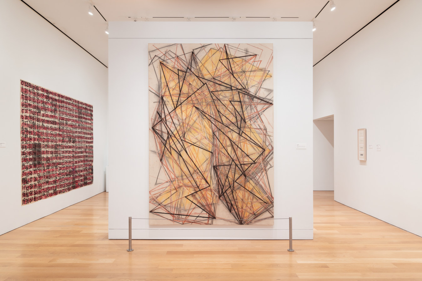 Color photograph of an art gallery interior, with two large abstract works visible.