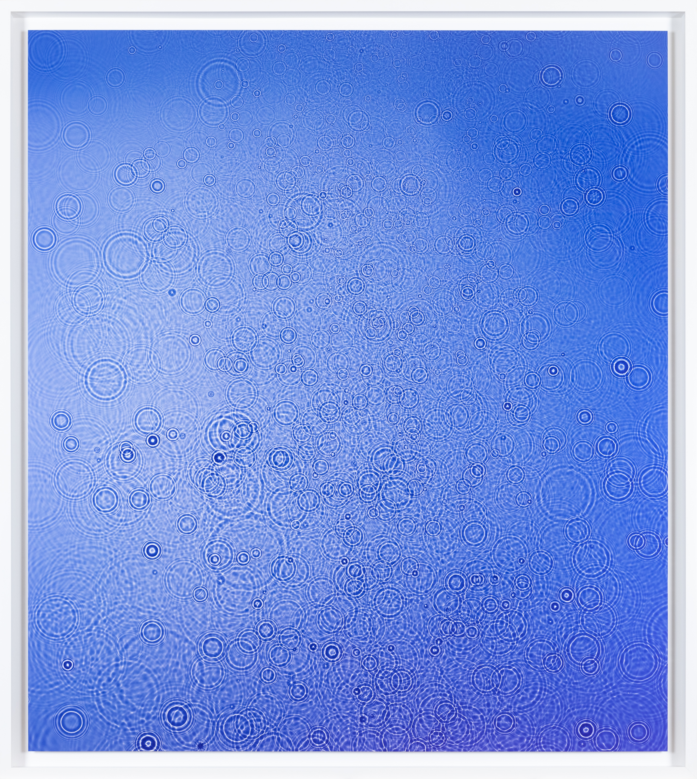 Color image of a color photograph of water droplets on blue background framed in white