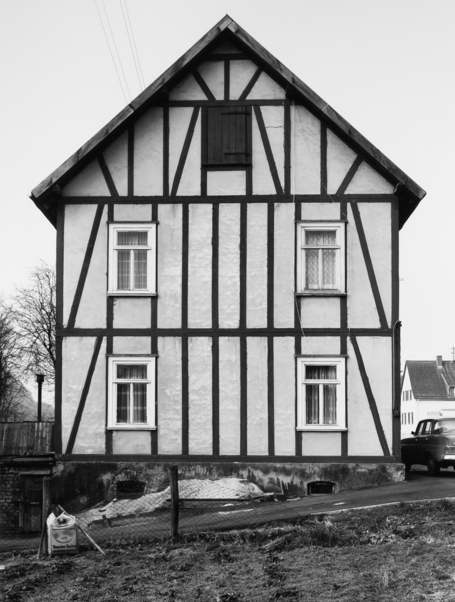 Black and white photograph of the exterior facade of a framework house