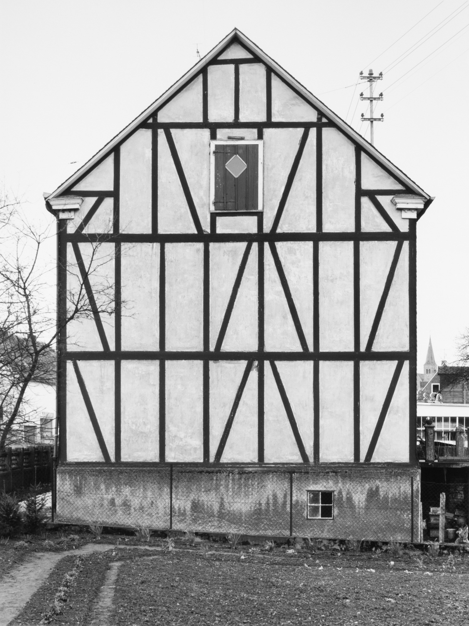 Black and white photograph of the exterior facade of a framework house