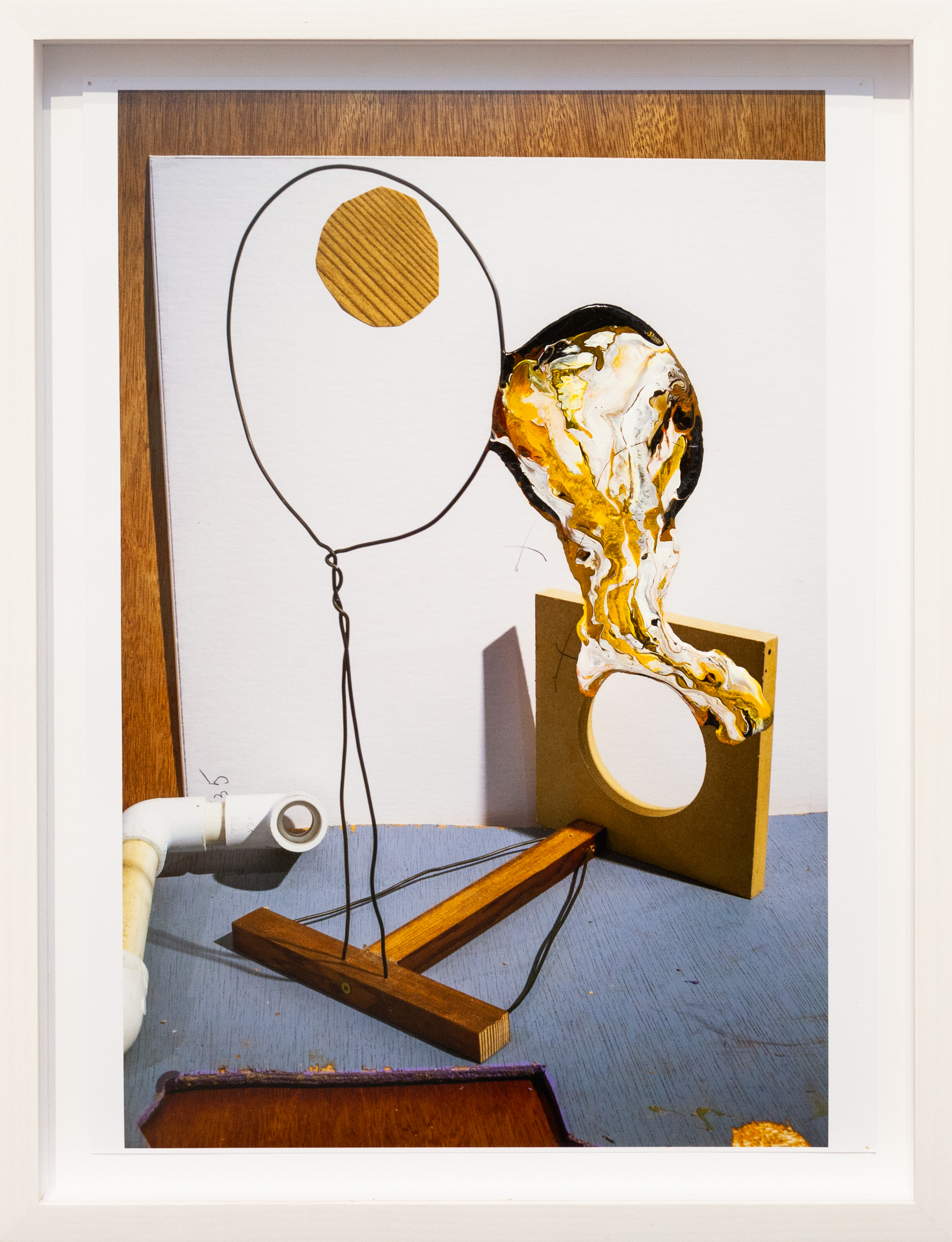 Color photograph with abstract paint splotches framed in white depicting a still life of utilitarian objects