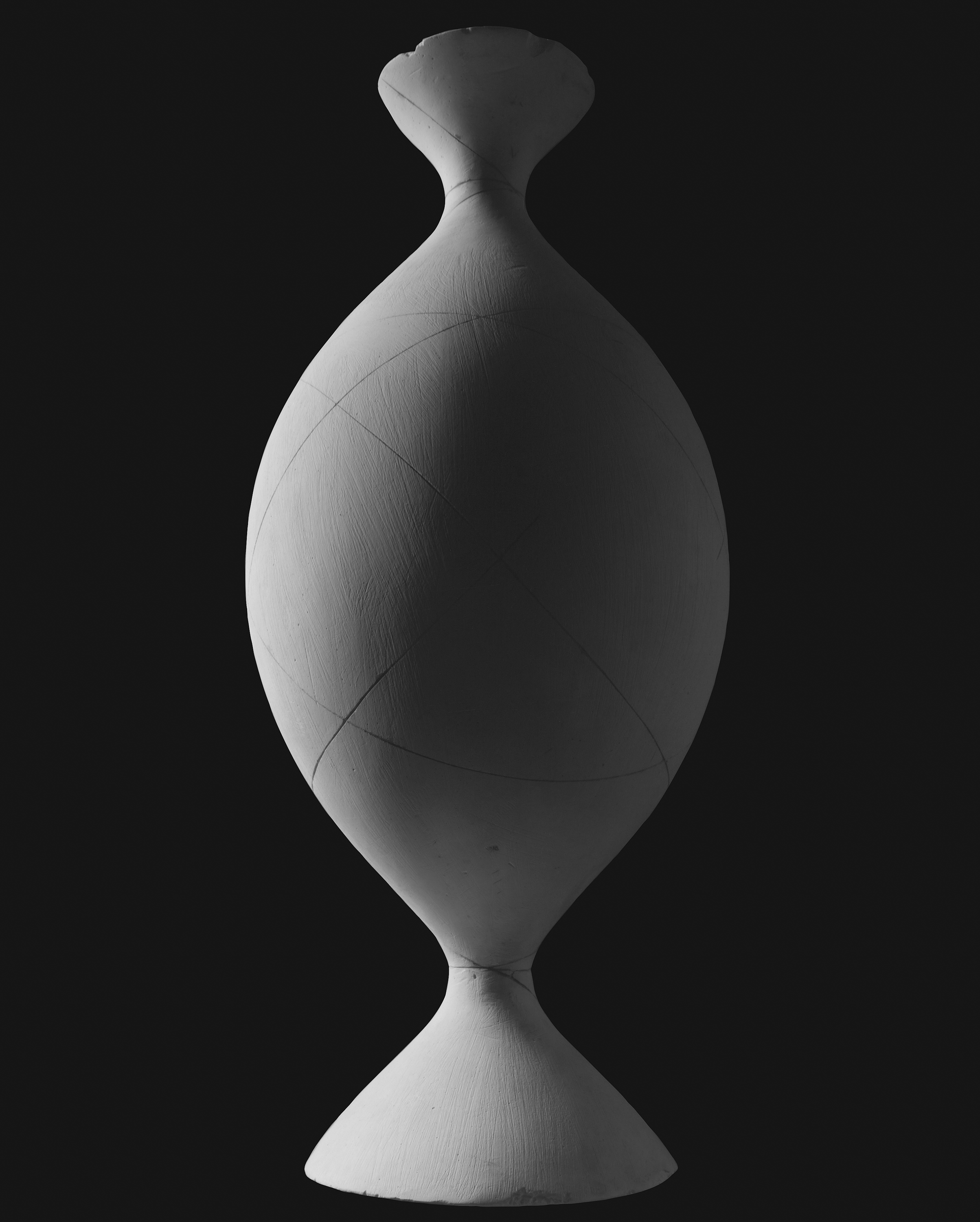 Black and white photograph of an hourglass shaped form with black background