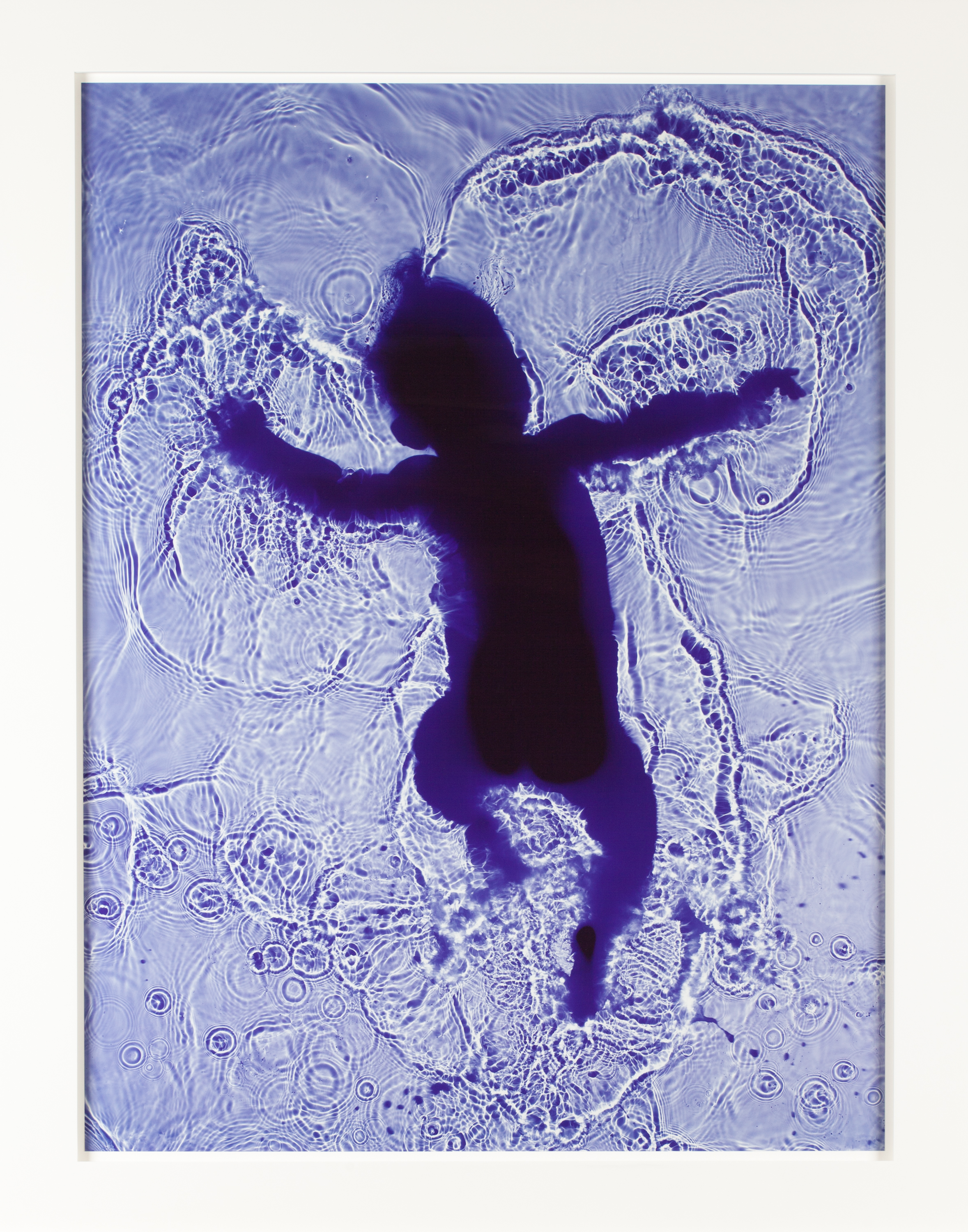 Color image of a purple tinted photogram of an infant wading in water framed in white