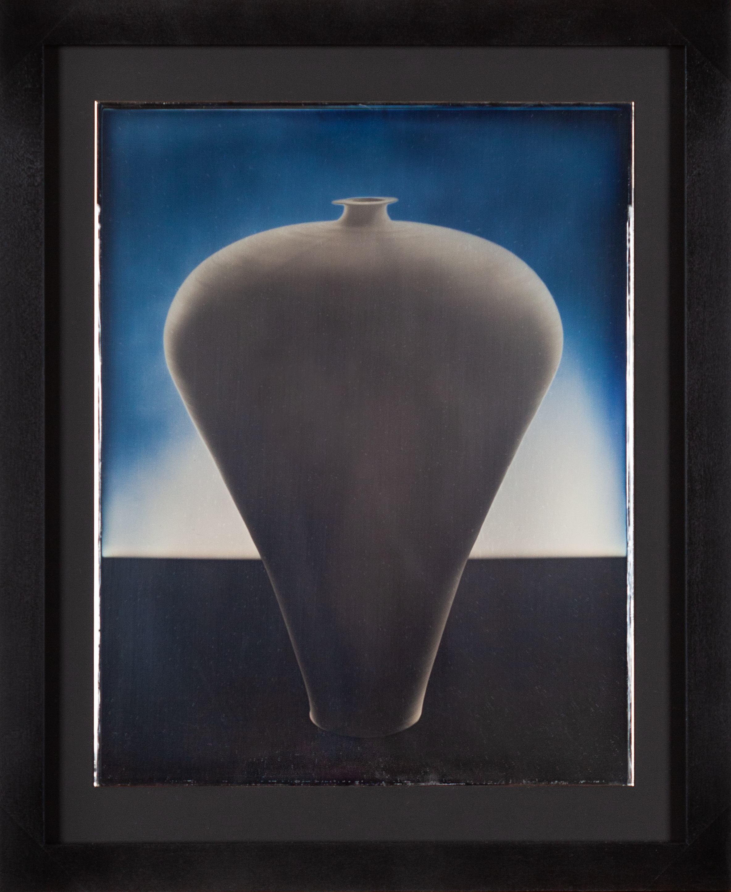Color image of a daguerreotype depicting a top heavy vase in a blueish hue framed in black