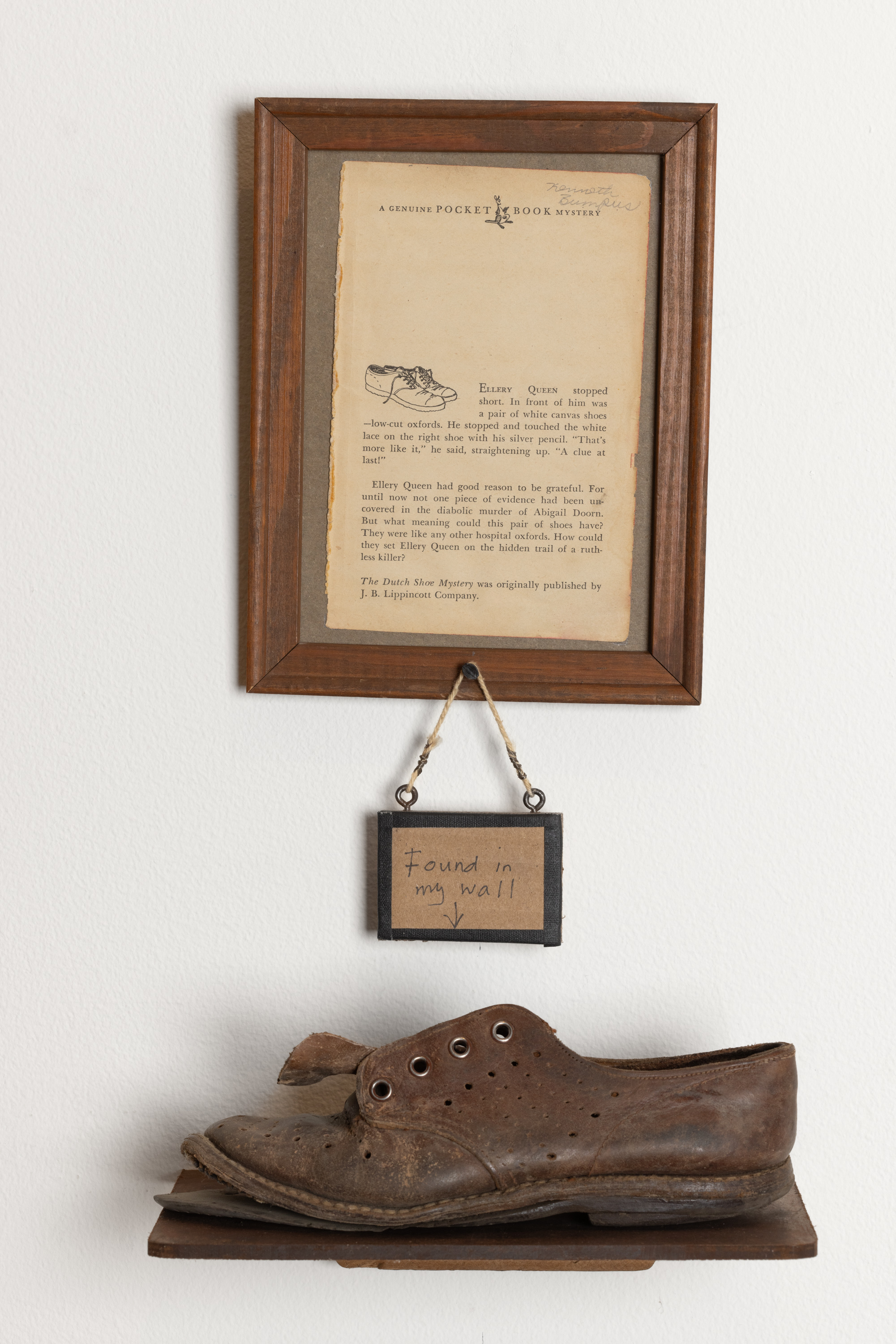Color image of a mixed media artwork of a found shoe and a framed page of a book