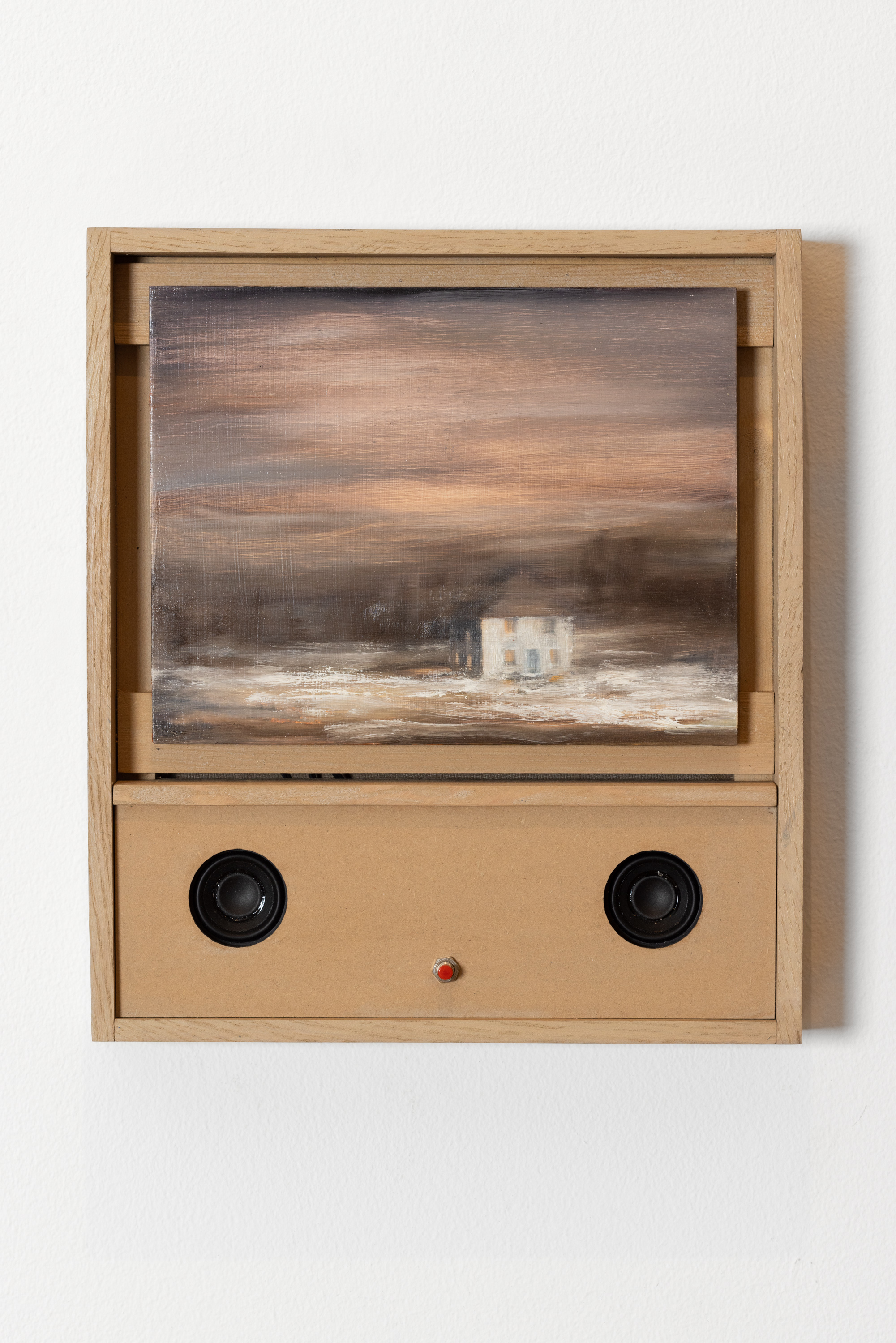 Color image of a mixed media artwork with an oil painting depicting a house in an empty filed attached to a wooden box with two speakers and a red button on a white gallery wall