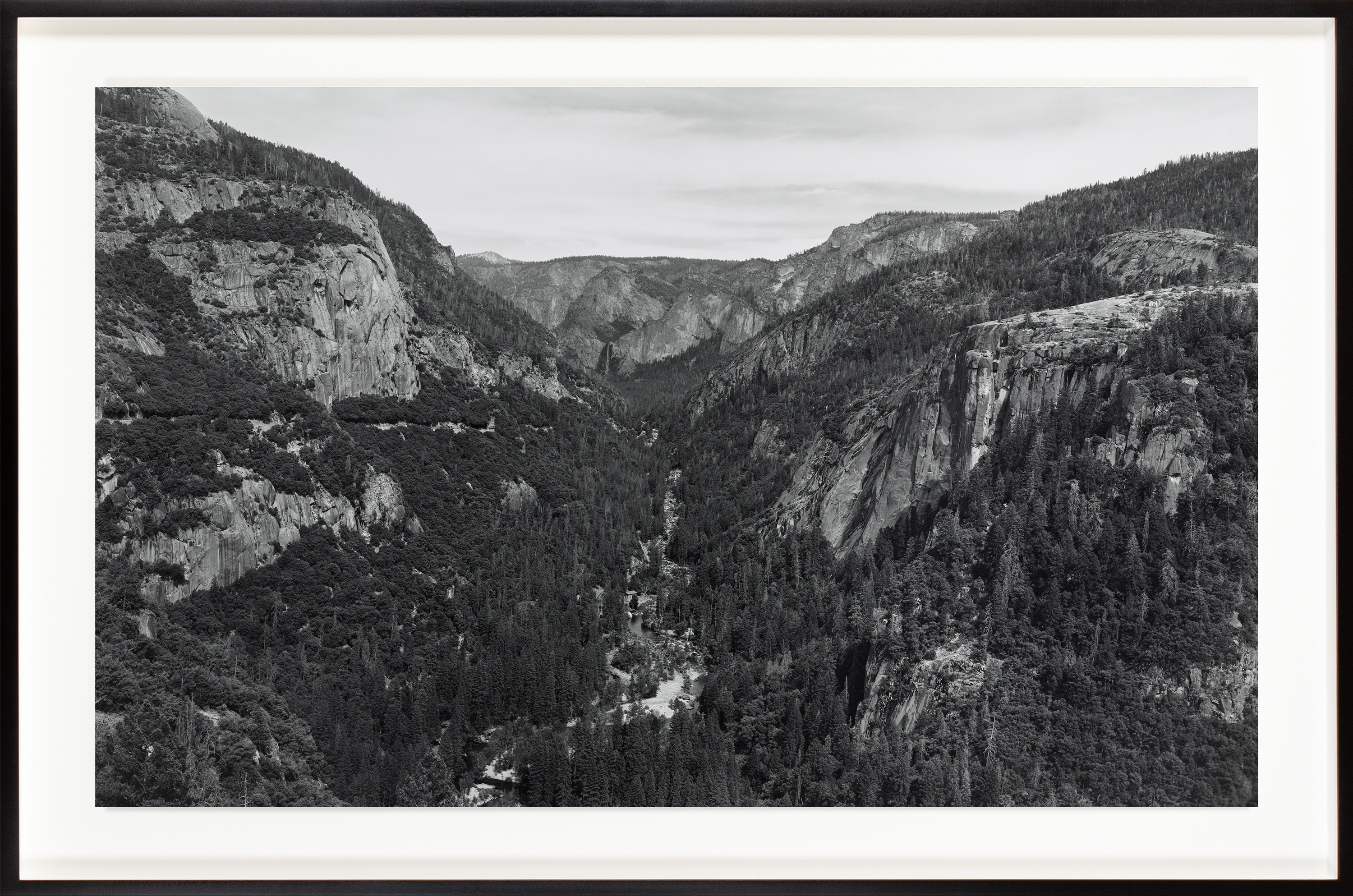 Black and white photograph of Yosemite valley with river running through middle framed in black