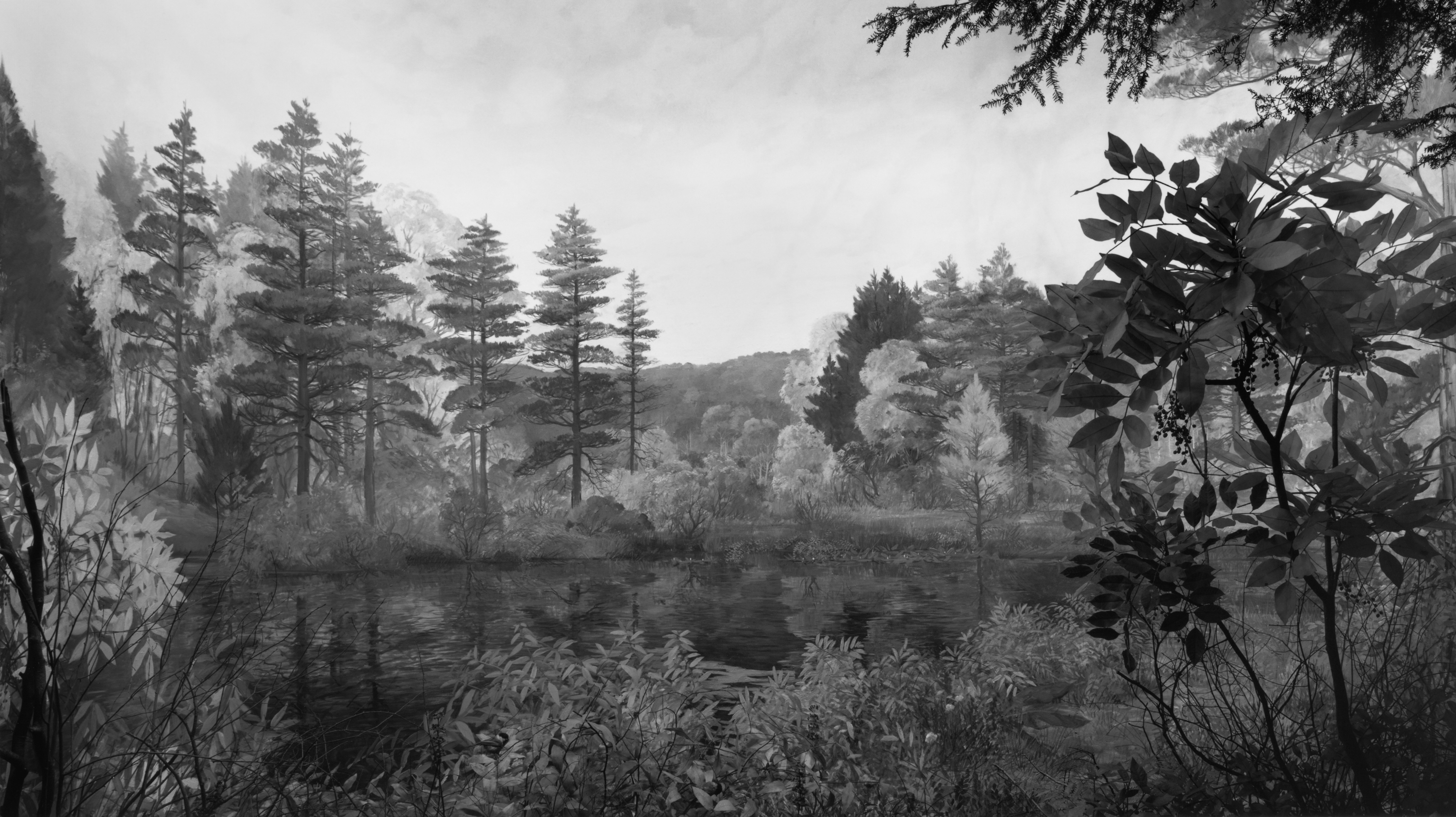 Black and white photograph of a diorama depicting a body of water surrounded by a verdant valley