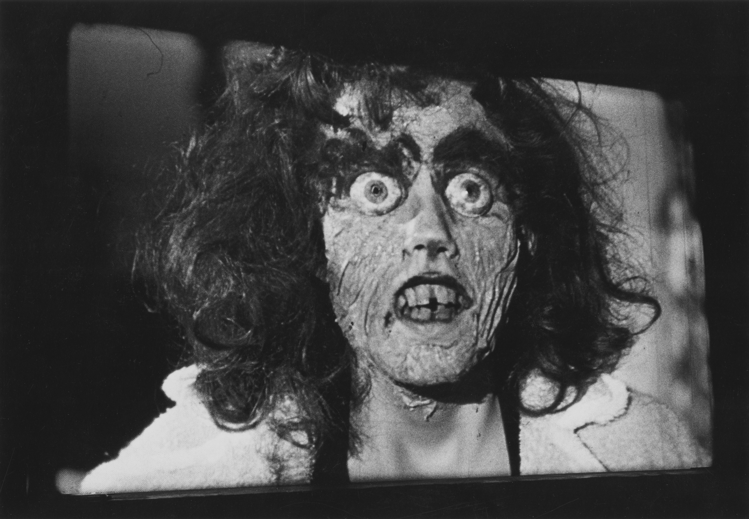 Black and white photograph of a monster appearing on a movie screen
