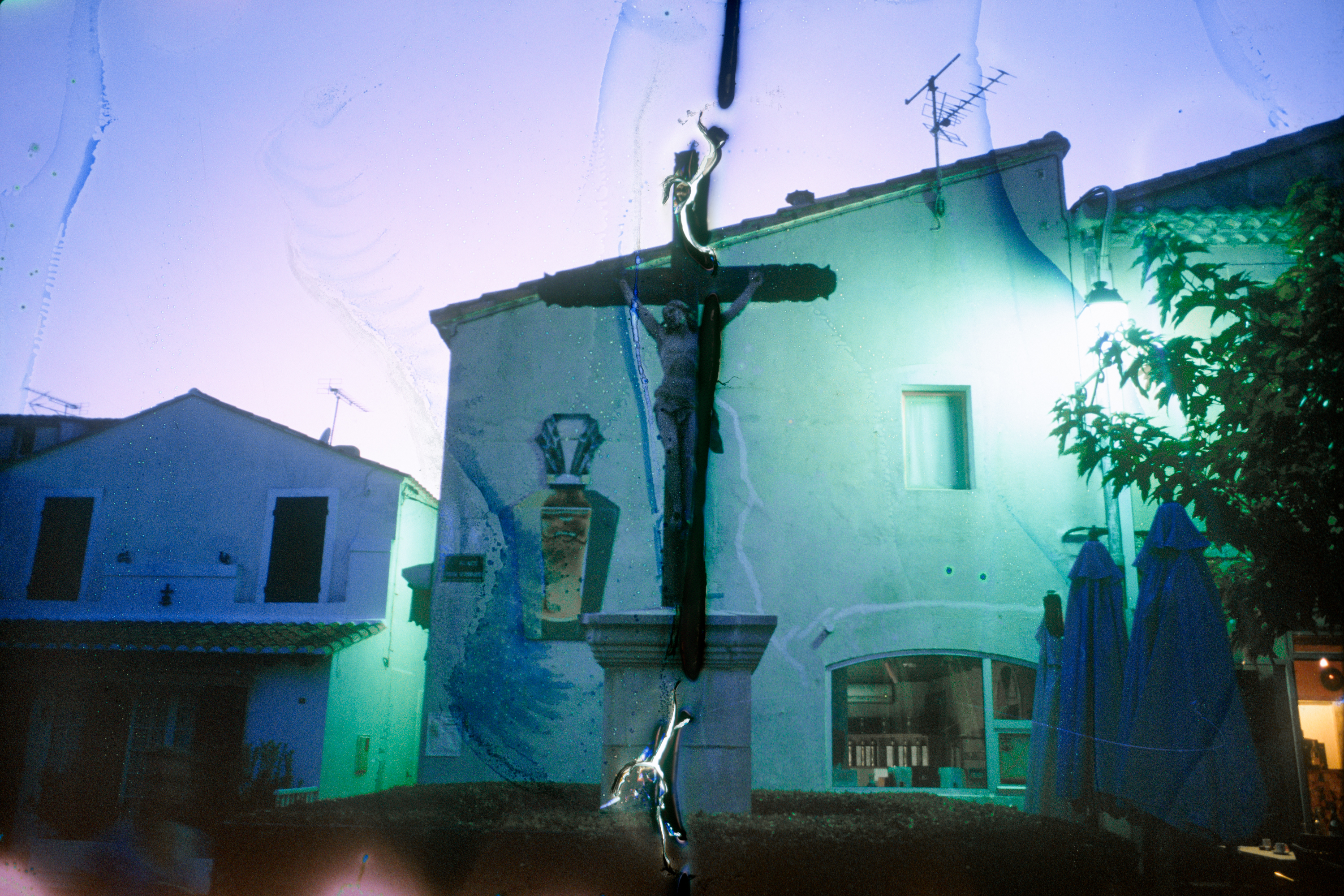 Color photograph of a statue depicting a crucified figure in middle of a town square