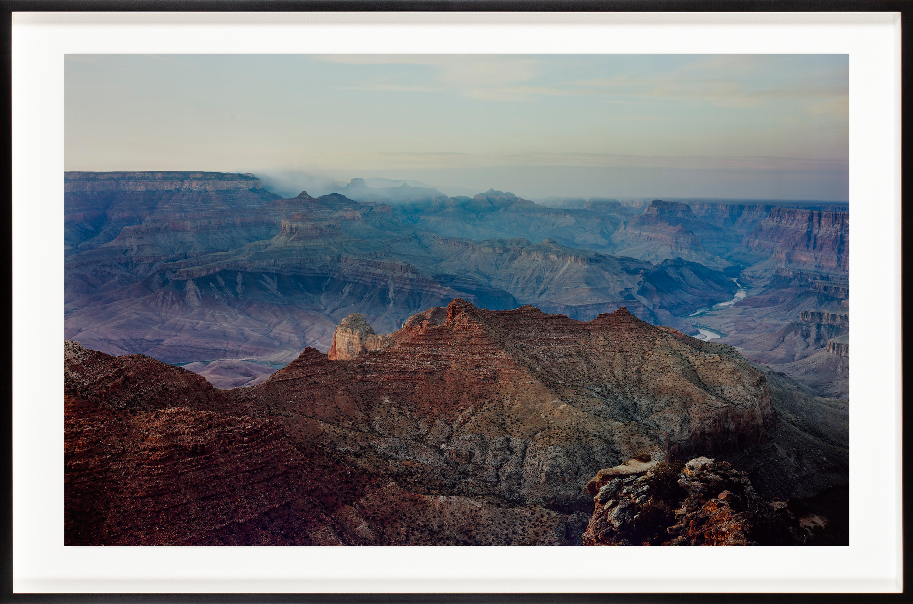 Color photograph of the Grand Canyon at sunset framed in black