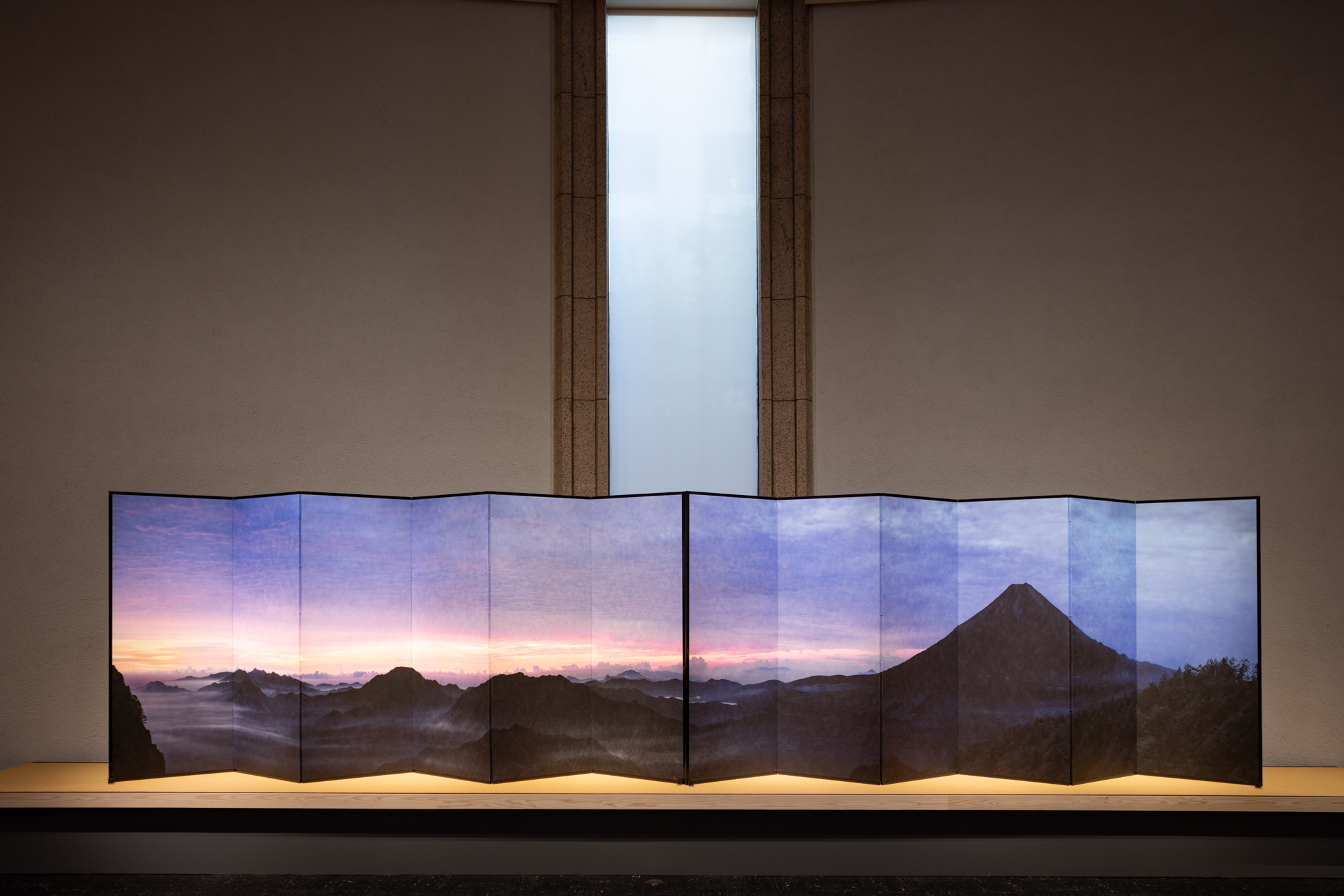 Installation view of a color photograph featuring a Mt. Fuji mounted on a folding screen