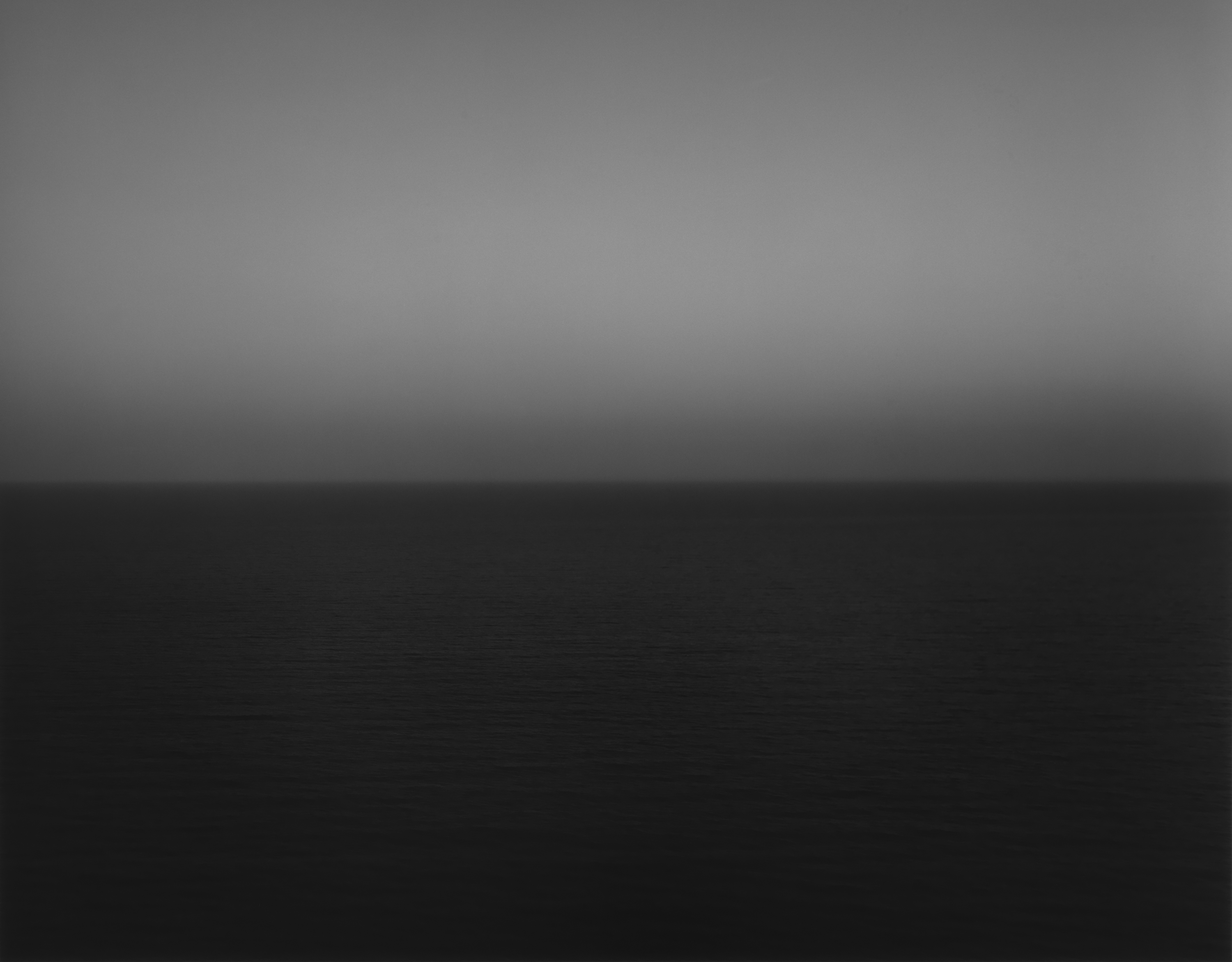Black and white photograph of the horizon with equal parts sky and sea