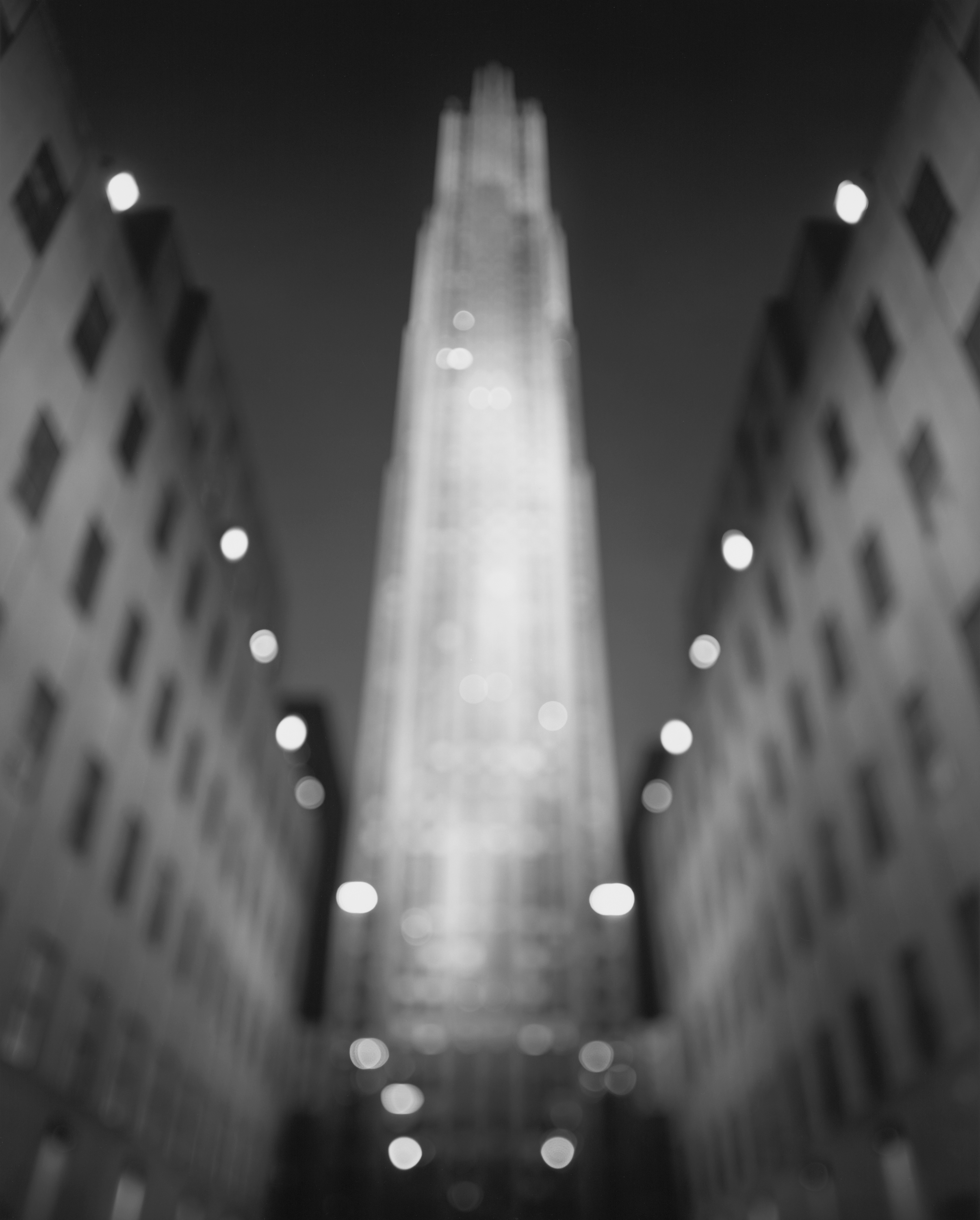 Black and white photograph of the Rockefeller building at night and out of focus