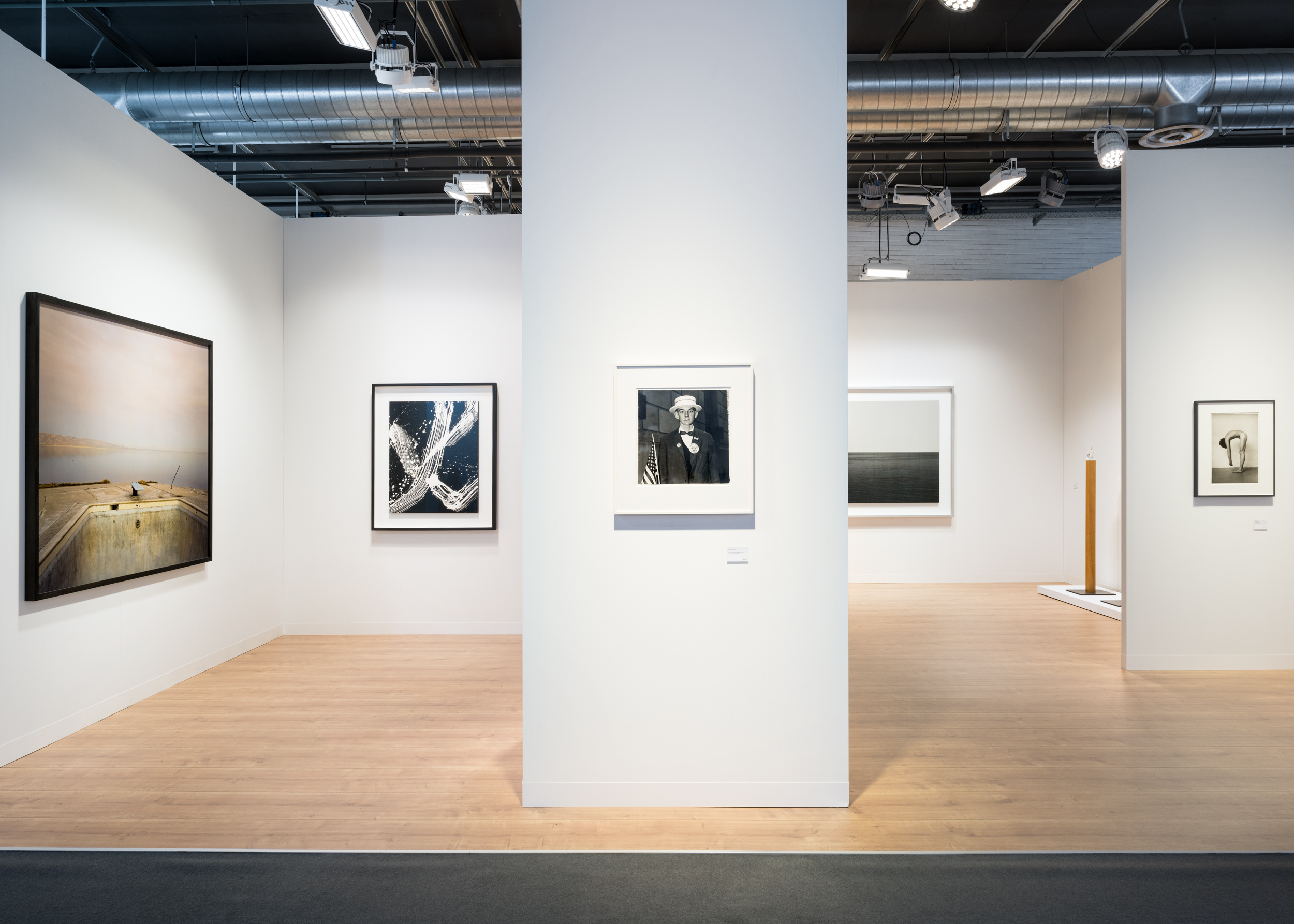 Color image of an art fair booth with a broad range of artworks in different mediums