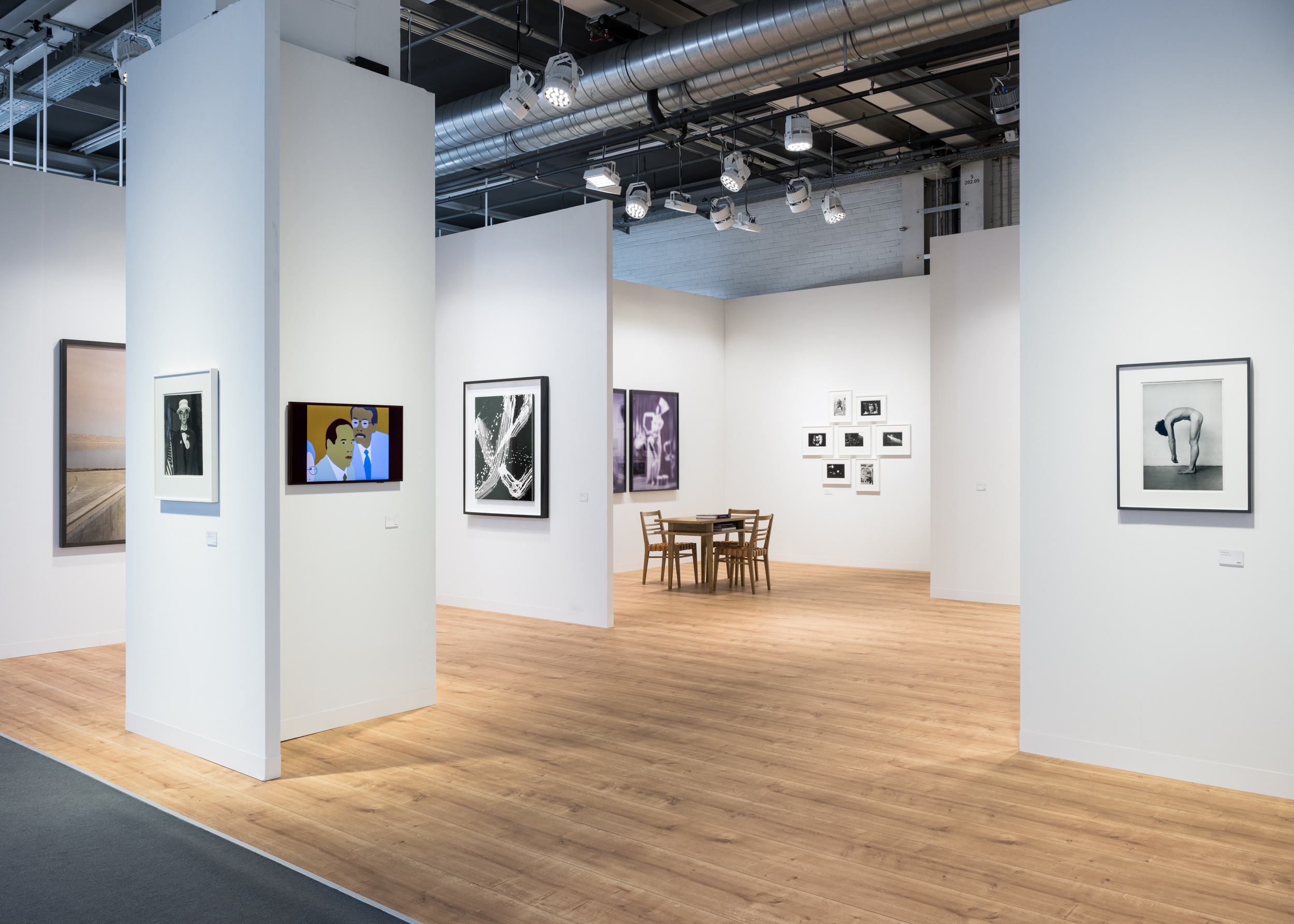 Color image of an art fair booth with a broad range of artworks in different mediums